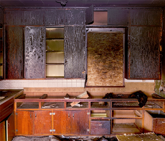 a fire damaged kitchen with burnt cabinets