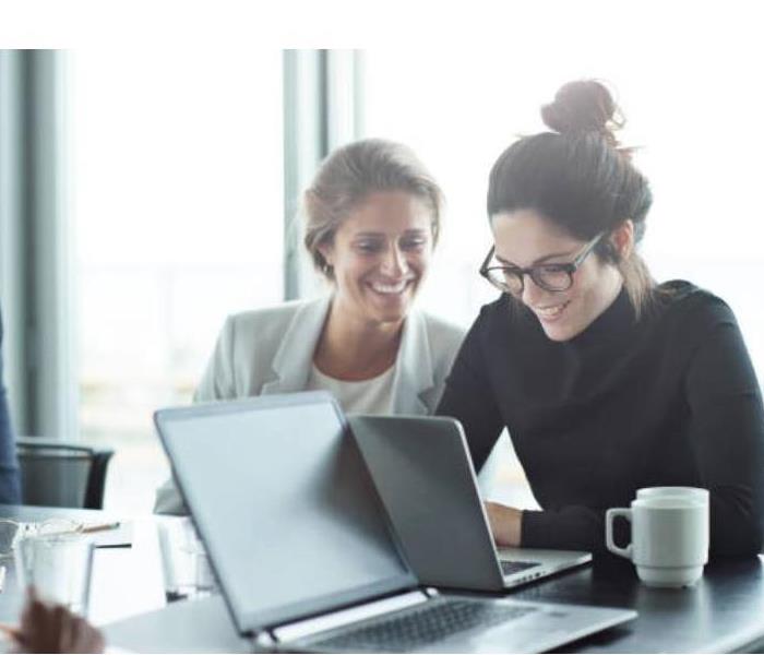 Two women looking at a computer.