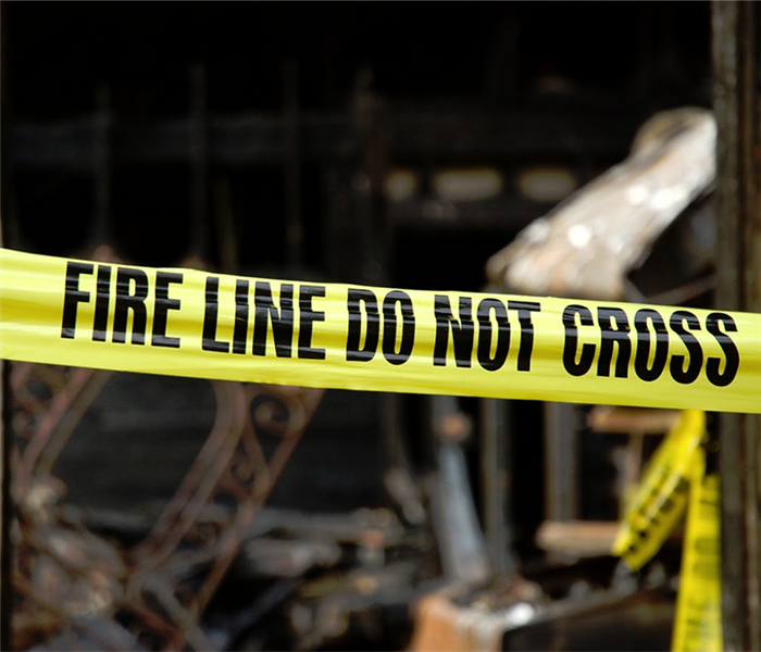 fire wrecked house with yellow tape over it